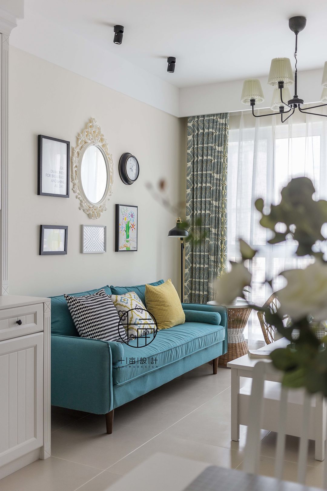 蓝色主沙发点缀跳色靠枕,背景采用不同的墙饰与简框画
